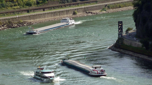 zwei Containerschiffe und ein Personenschiff in einer Biege auf dem Rhein