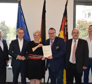 Staatssekretär Andy Becht übergibt den Förderbescheid Eva Kreienkamp, Geschäftsführerin der Mainzer Verkehrsgesellschaft mbH. v.r.n.l. Michael Meier (Mainzer Verkehrsgesellschaft), Dr. Andreas Neff (Referent im Ministerium für Wirtschaft, Verkehr, Landwirtschaft und Weinbau) Staatssekretär Andy Becht, Eva Kreienkamp (Geschäftsführerin Mainzer Verkehrsgesellschaft mbH), Christoph Schultze (Berater Abteilung Kompetenzzentrum Intelligente Mobilität) und Anton Kirmaier (Mainzer Stadtwerke)
