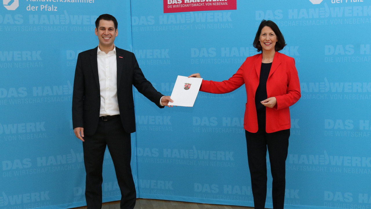 Wirtschaftsministerin Daniela Schmitt überreicht Dr. Till Mischler, Hauptgeschäftsführer der HWK der Pfalz, einen Förderbescheid.